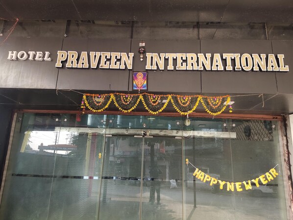 The exterior of Hotel Praveen International with a 'Happy New Year' banner. - Hotel Praveen International (Ambernath)