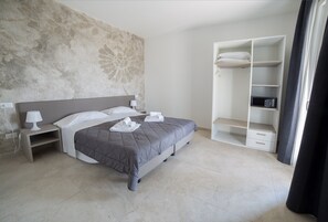 A bedroom with a bed, bedside table, lamp, and a wardrobe.
