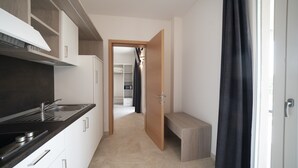 Una cucina moderna con piano cottura integrato, lavello e una panca in legno.