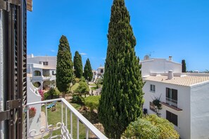 Un quartier résidentiel avec des bâtiments blancs, des arbres verdoyants et un ciel bleu azur.