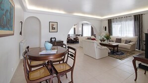Un salon comprenant une table à manger, des chaises, un canapé et un téléviseur.