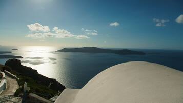 A coastal view with a white building, a clear sky, and calm sea.