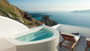 A hot tub with a view of the sea, wooden lounge chairs, and a white tiled floor. - Caldera's Majesty (Santorini)