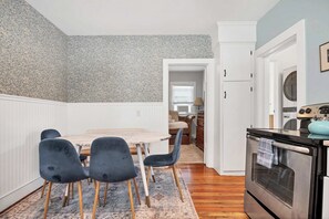 Una cocina con comedor, armarios de madera y una estufa moderna.