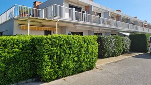 A multi-story residential building with balconies, a covered entrance, and a well-maintained hedge in front. - Ground-Floor Studio Cabin for 4 with Terrace – 300m from Beach & Shops (Argelès-sur-Mer)