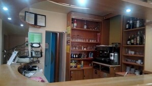A kitchen area with wooden cabinets, a coffee machine, and various kitchen appliances.