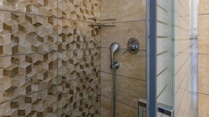 A shower area with a geometric tile wall and a glass door. - Casa De' Fiori Kefalonia★Studio 3 (Σκάλα)