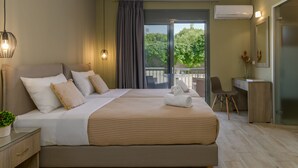 A modern hotel room with a large bed, a desk, and a balcony with a view of greenery. - Casa De' Fiori Kefalonia★Studio 3 (Σκάλα)