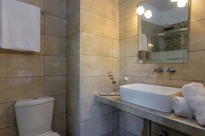 Features a sleek sink, glass shelf, large mirror, and towel rack.
