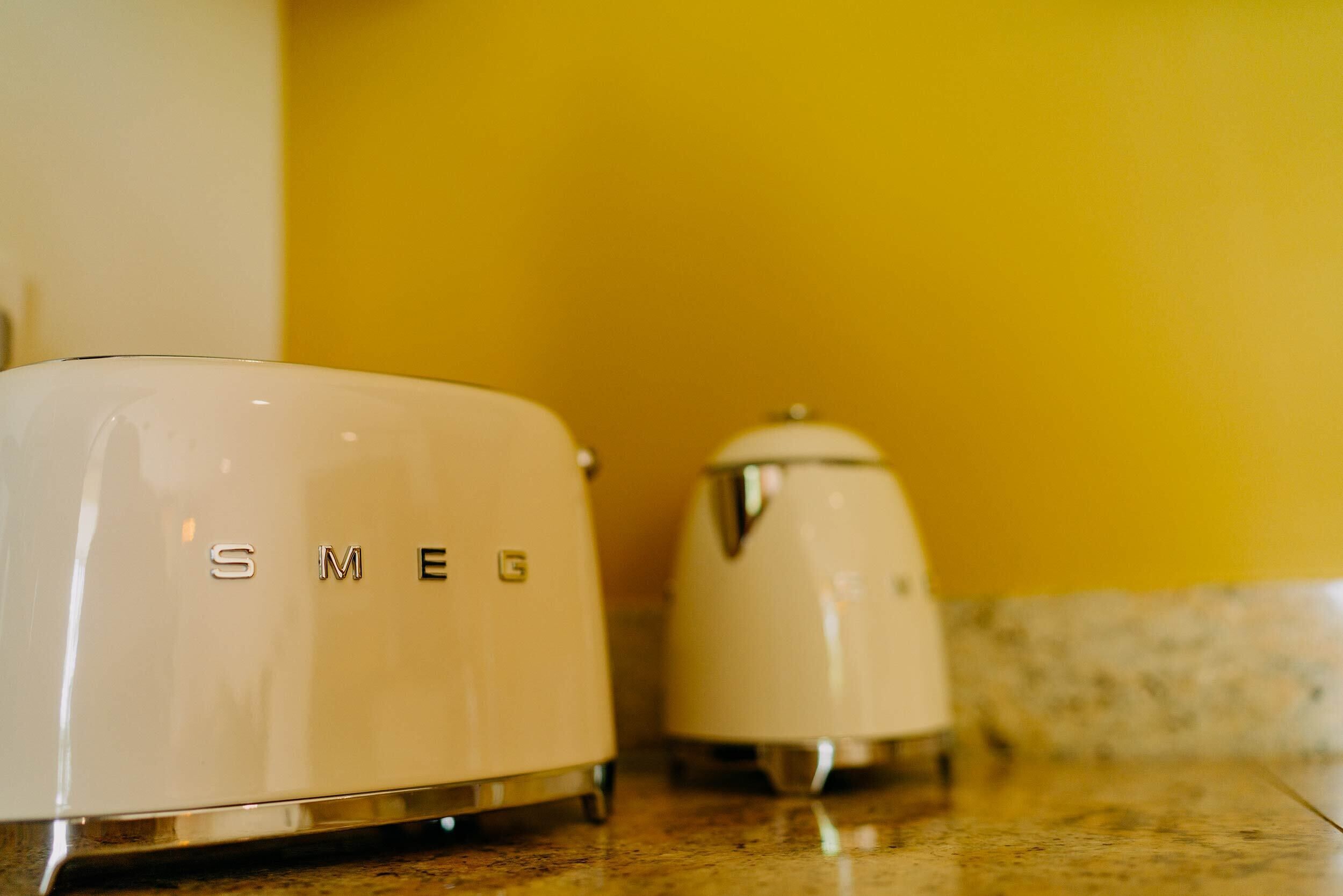 Two white appliances with the brand name 'SMEG' on a kitchen countertop.