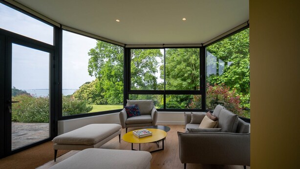 A modern living room with large windows, a sofa, a chair, and a coffee table. - Le Corentin        . (Concarneau)