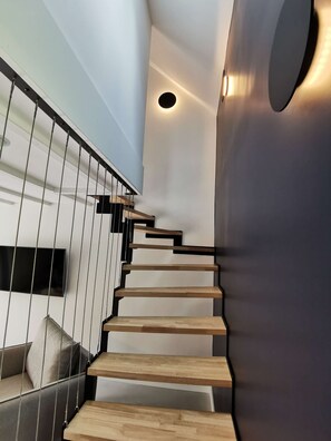 A modern staircase with wooden steps and a metal railing.