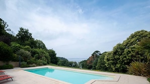 Una piscina rectangular amb una superfície d'aigua blava cristal·lina, envoltada per una zona de paviment.