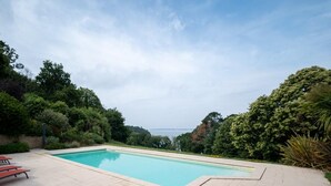 Una piscina con vista sul mare, immersa nel verde.