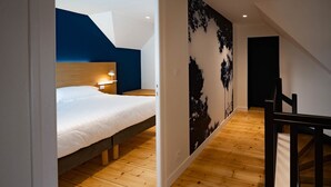 Una camera da letto con un letto, un comodino e una lampada a parete.