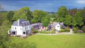 A large estate with multiple buildings, including a main house with a large garden and a smaller structure with a red door. - L'Etoile du Roy    . (Concarneau)