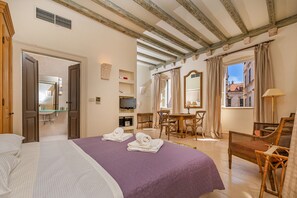 A hotel room with a bed, a desk, a chair, a television, and a window with curtains. - Apartments Game (Dubrovnik)
