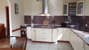 A kitchen with white cabinets, a granite countertop, a gas stove, and a stainless steel range hood. - Villa Leika - for families with a view of the Schneekoppe, dogs allowed (Mysłakowice)