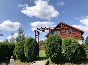 A wooden house with a balcony, surrounded by well-maintained hedges. - Villa Leika - for families with a view of the Schneekoppe, dogs allowed (Mysłakowice)
