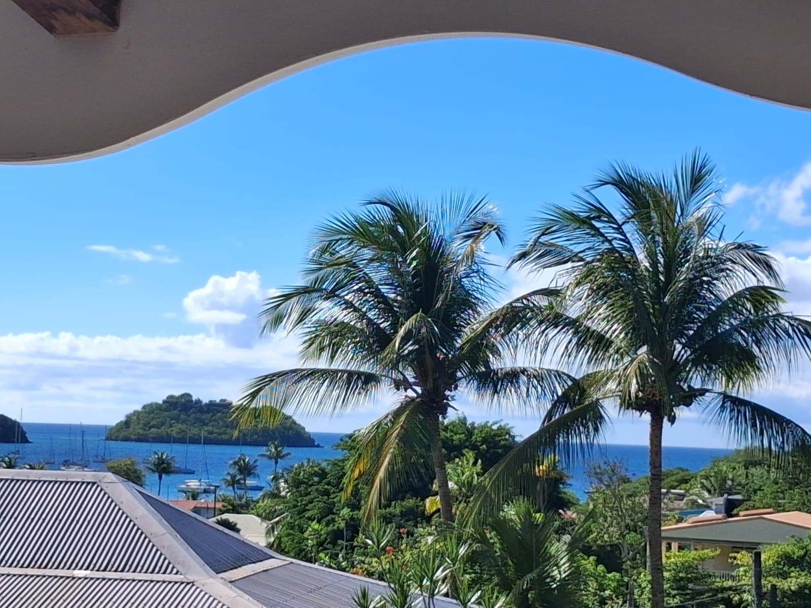 A tropical resort with a view of the ocean and a small island.
