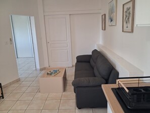 Ein Wohnzimmer mit einer Couch, einem Couchtisch und einer wandmontierten Ablagefläche.