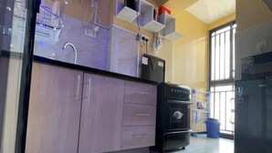 Une cuisine équipée d’un four encastré, d’un réfrigérateur et d’un évier. Elle comprend également des placards et un plan de travail.