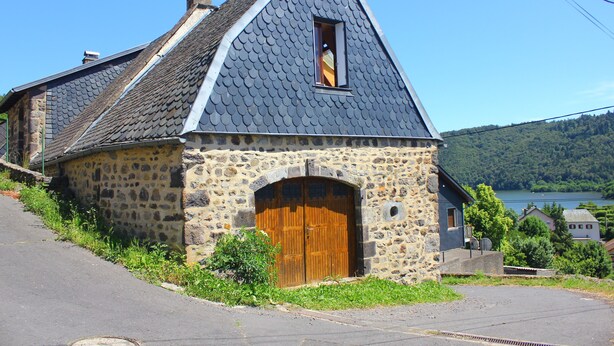 Un edificio de piedra con un techo empinado y una puerta de madera.