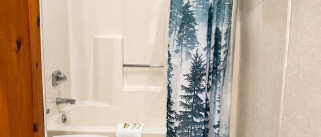 A bathroom with a shower, toilet, and bathtub.