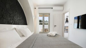 Un dormitorio moderno con una cama grande, un televisor de pantalla plana y vistas al exterior.