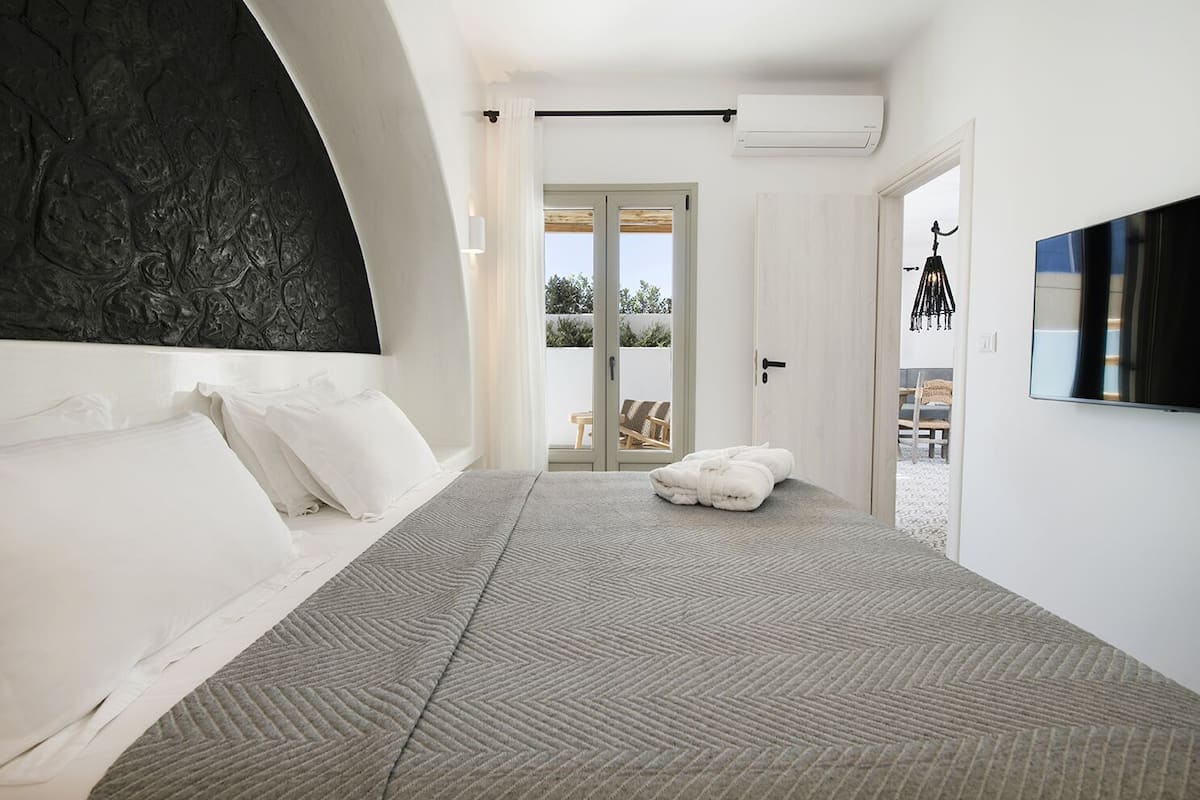 Un dormitorio moderno con una cama grande, un televisor de pantalla plana y vistas al exterior.