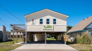 A two-story building with a covered front porch and a sign reading 'Cecelia by the Sea'.