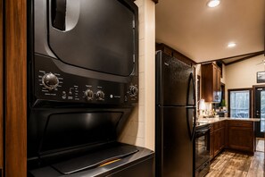 Una cocina compacta con horno integrado, refrigerador y armarios de madera.