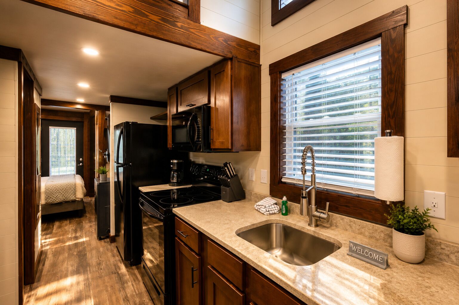 A compact kitchen with a built-in stove, microwave, and sink.