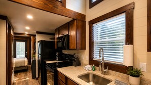 Cocina compacta con estufa integrada, microondas y lavabo.