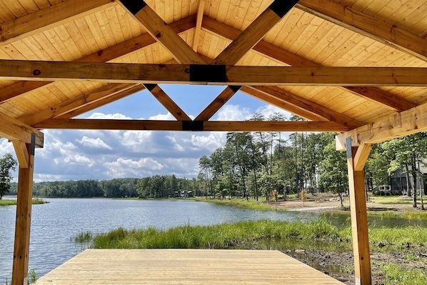 Terraza de madera con vista a un lago y un bosque.