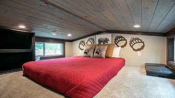 Ein Schlafzimmer mit einem großen Bett, einem Flachbildfernseher und einem Fenster.