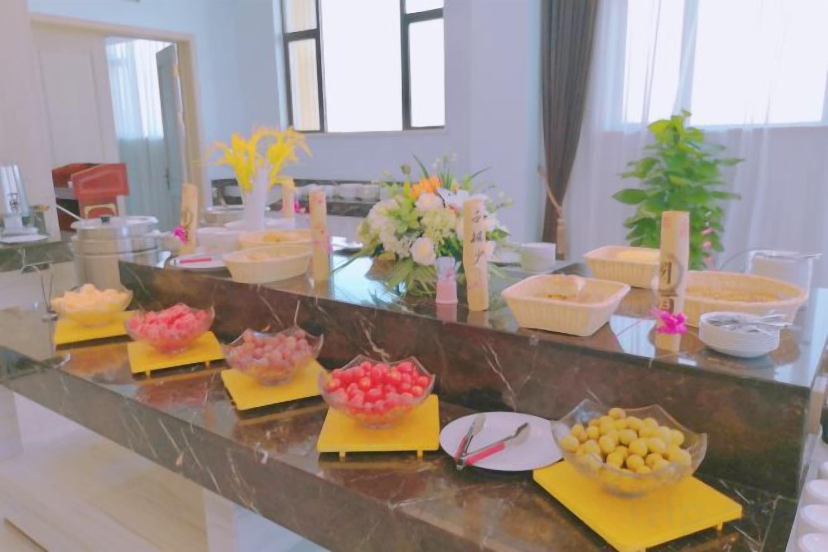 A buffet setup with various food items and utensils on a marble counter.
