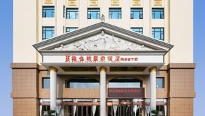 A hotel entrance with a classical facade, columns, and a red carpet leading to the doors. - Vienna International Hotel (Wenzhou Rui'an Tangxia) (Rui'an)