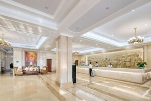 A spacious lobby with a reception desk, seating area, and a large mural. - Vienna International Hotel (Wenzhou Rui'an Tangxia) (Rui'an)