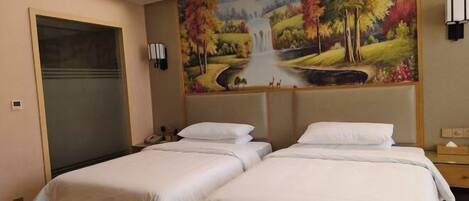 A hotel room with two beds, a large painting of a landscape, and a door.