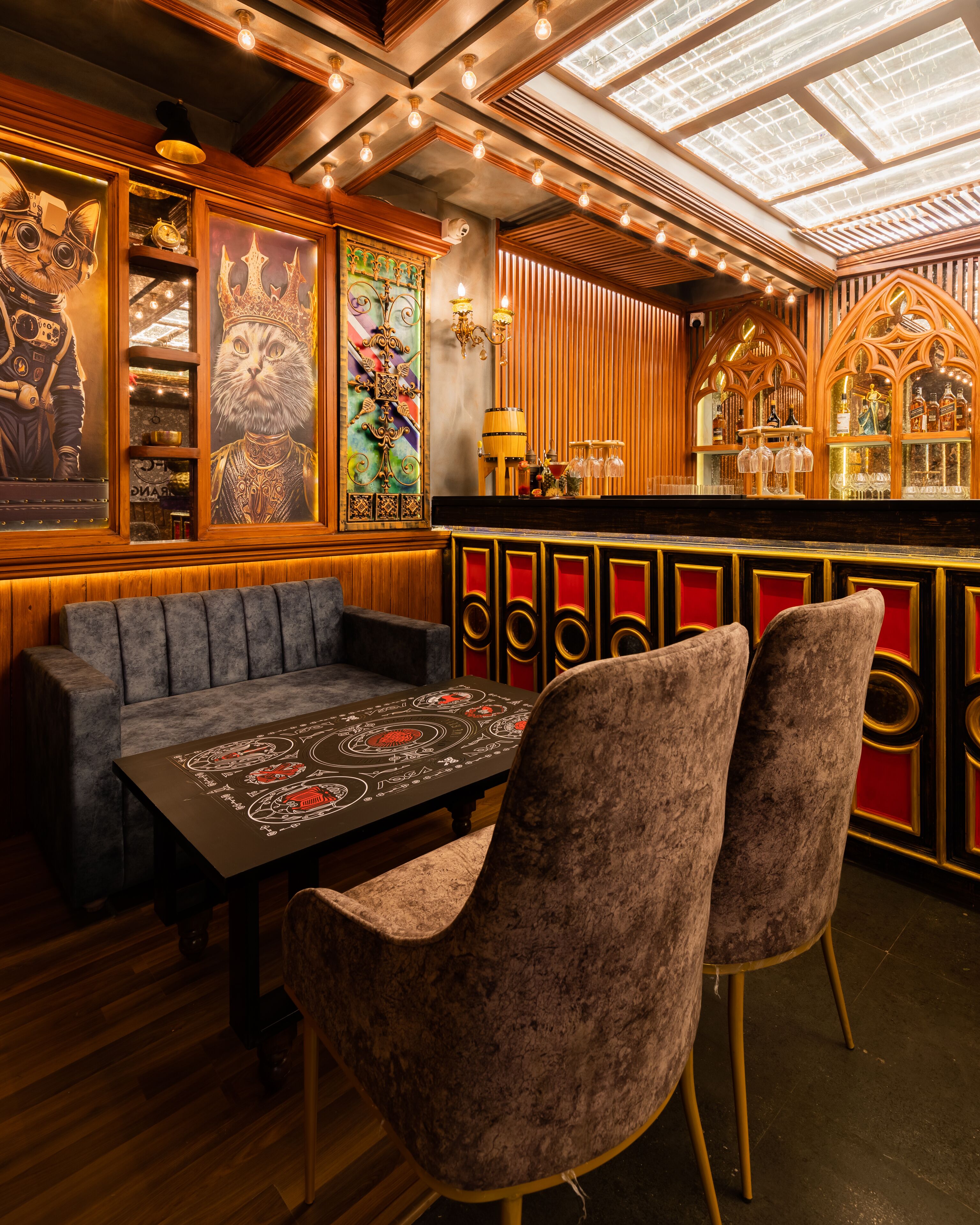 Zona de bar con mostrador de madera, asientos acolchados y una mesa con camino de mesa decorativo.