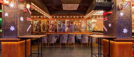 A bar area with wooden paneling, star decorations, and a variety of framed artworks on the walls.