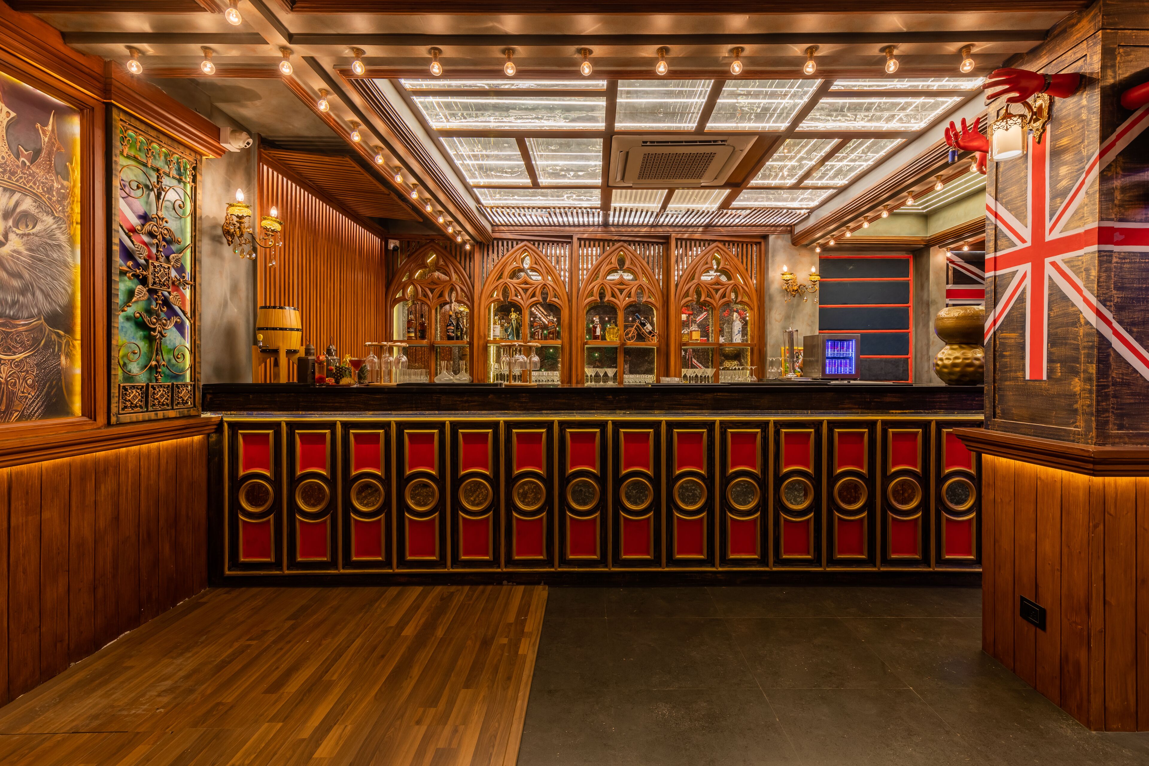 A bar area with wooden paneling, a glass enclosure, and a red and gold color scheme.