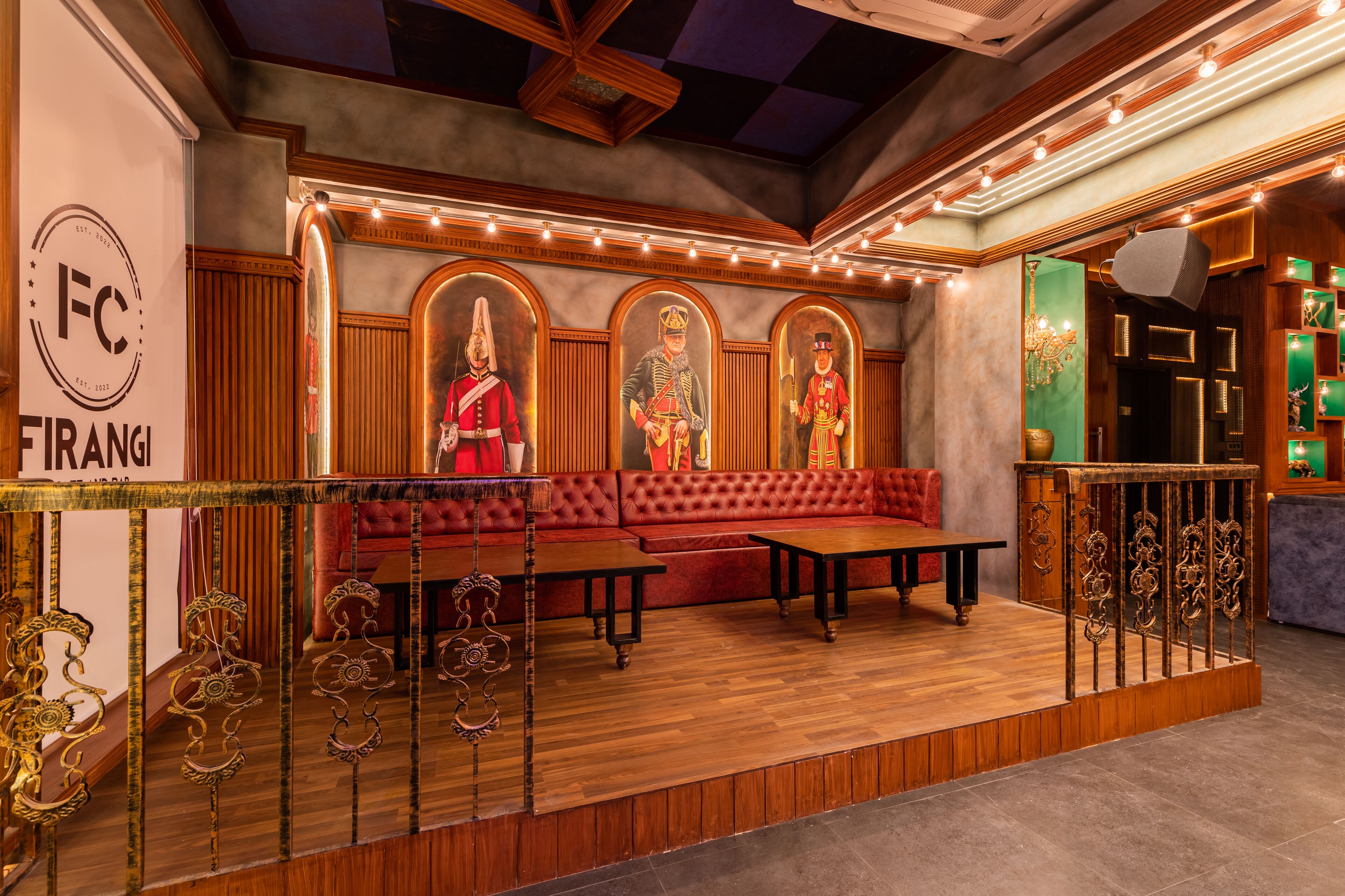 A lobby with a red sofa, wooden flooring, and a decorative railing.