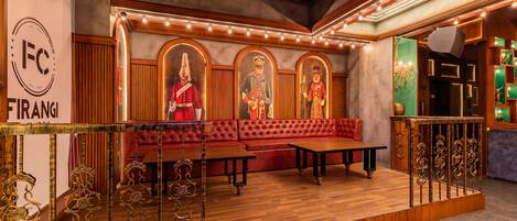 A lobby with a red sofa, wooden flooring, and a decorative railing.