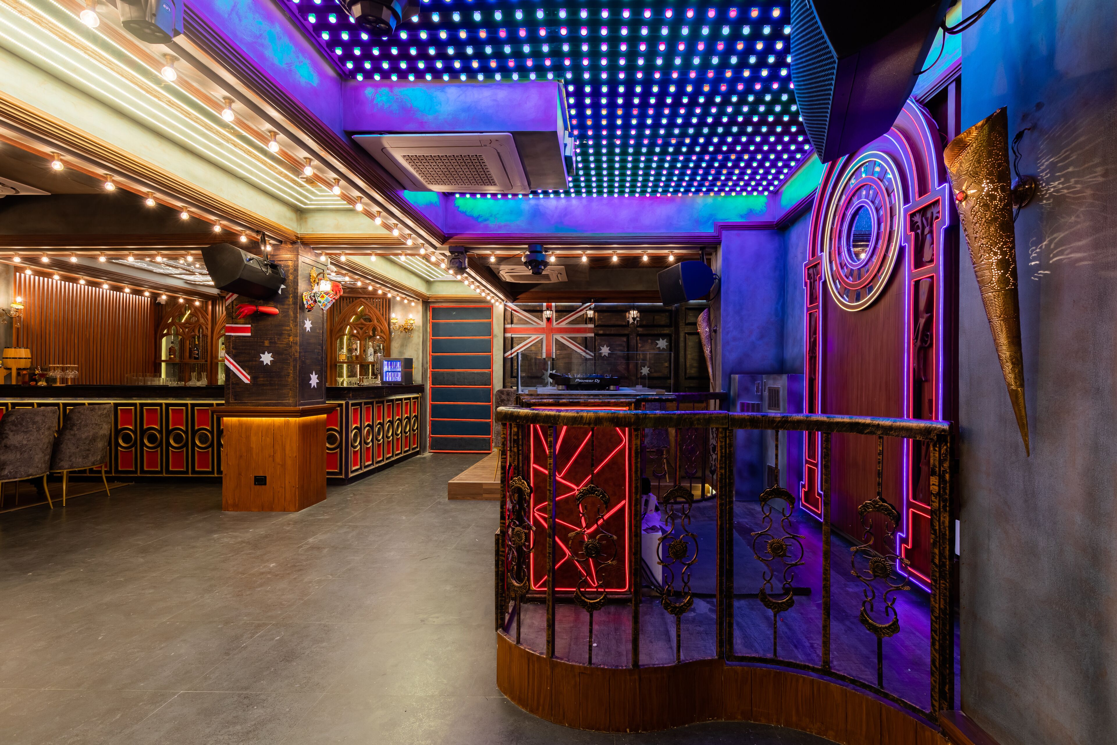 A bar area with a curved counter and neon lighting.