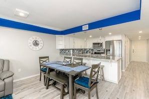 Enjoy meals in the spacious kitchen and dining area, featuring a central island and wooden table.