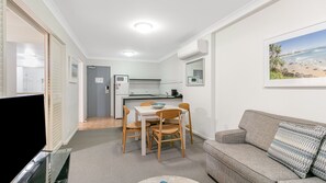 Cozy living space with a dining table, flat-screen TV, and sofa.