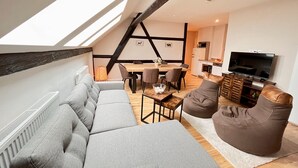 Un loft moderno con comedor, cocina y un televisor grande.