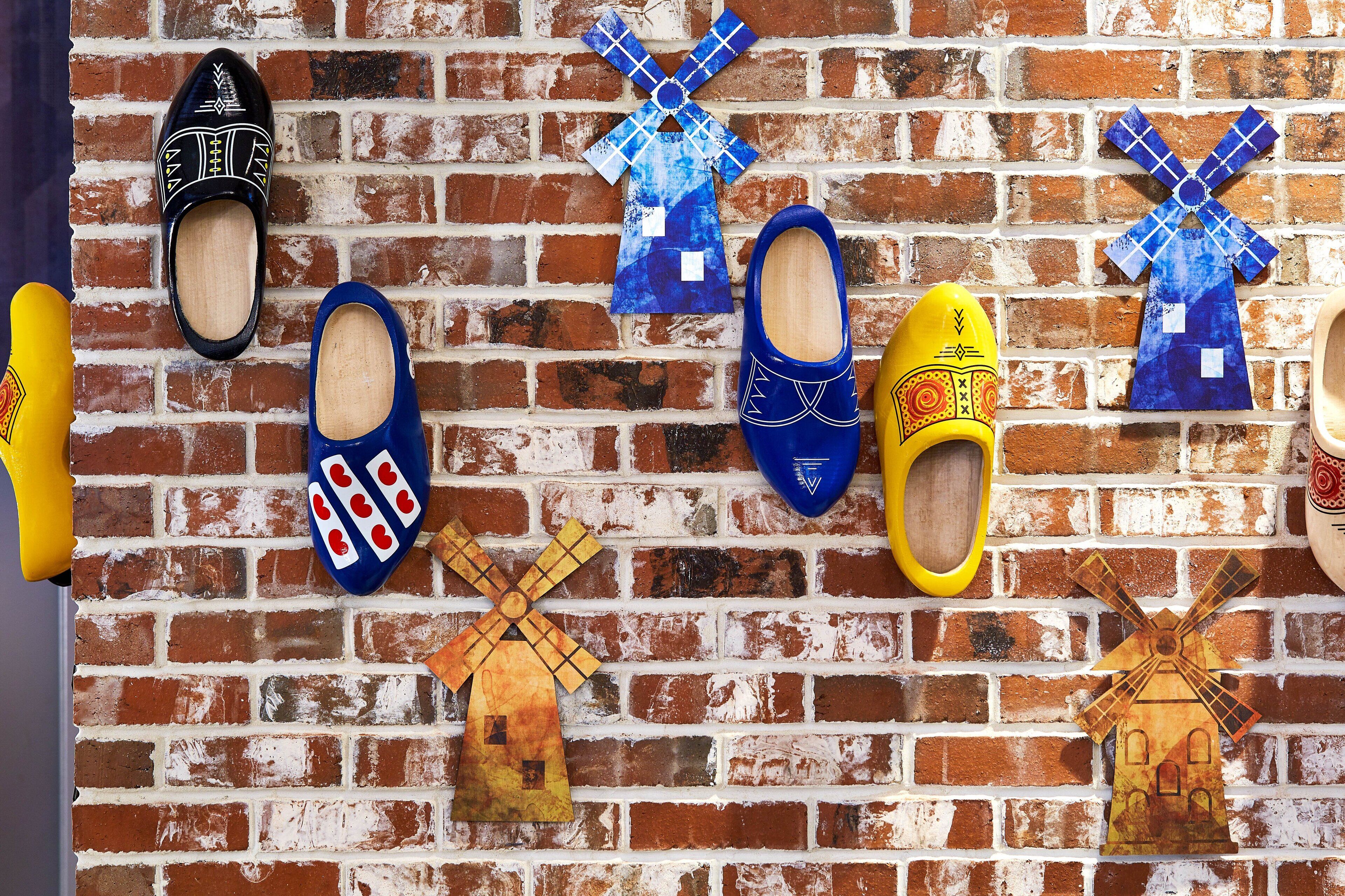 Un muro de ladrillo con varios molinos y zapatos exhibidos.